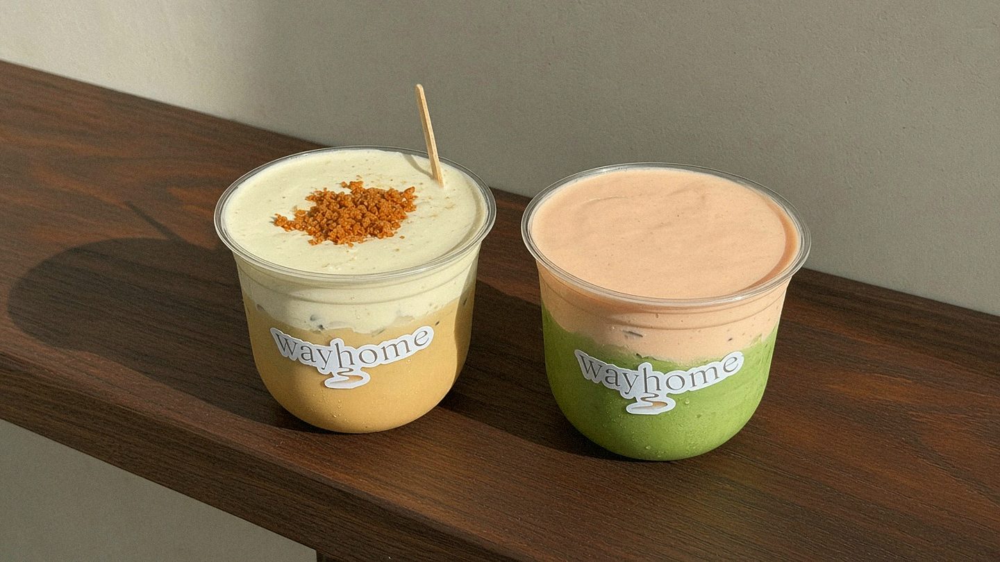 Banana cream injeolmi latte and peach yogurt matcha latte on the walnut bench in afternoon sun.