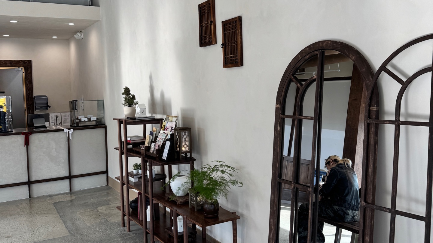 Inside Way Home Coffee: plaster walls, arched wooden mirrors, and the counter.