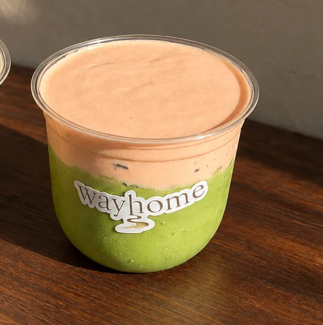 Close-up of the peach yogurt matcha latte in a wayhome cup.